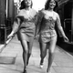 Moya Gillett, left, and Lina Huby hold hands as they walk in their paper mini-dresses on a sidewalk in London, England on April 7, 1970.
